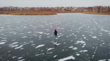 Hava görüntüsü. Buzda kış eğlencesi. Yüksekten güzel bir atış, bir kadın donmuş bir gölette kanyonlara biner..