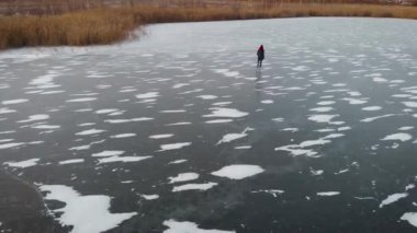 Hava görüntüsü. Buzda kış eğlencesi. Yüksekten güzel bir atış, bir kadın donmuş bir gölette kanyonlara biner..