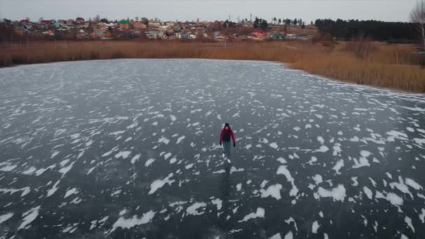 Letecký pohled. krásná zmrzlá řeka nebo jezero. Muž bruslí na ledě. — Stock video