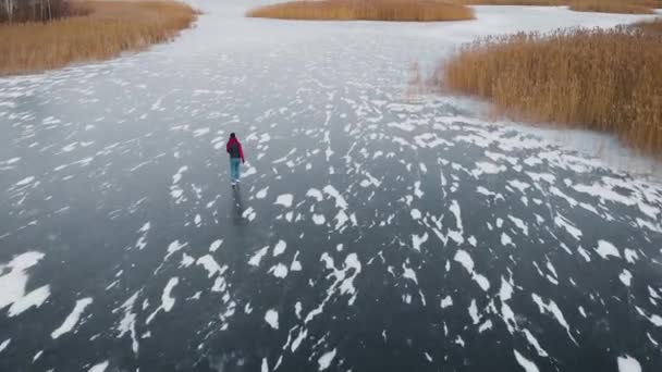 Αεροφωτογραφία. Μια νεαρή γυναίκα κάνει πατινάζ σε μια παγωμένη λίμνη. — Αρχείο Βίντεο