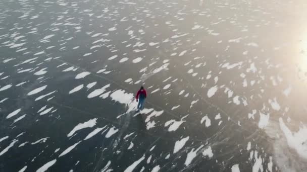 空中风景。美丽的冰冻河流或湖泊。一个男人在冰上滑冰. — 图库视频影像