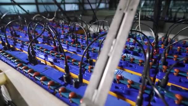 Een standaard voor het opladen van nieuwe batterijen in de fabriek. Auto-accu 's worden in serie aangesloten. — Stockvideo