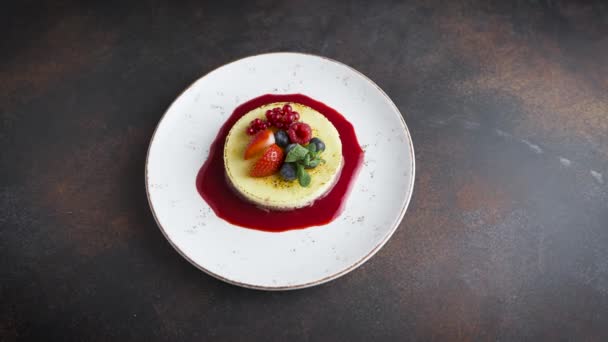 Ovanifrån av en läcker dessert. Tiramisu eller ostkaka garnerad med mynta och färska bär. — Stockvideo