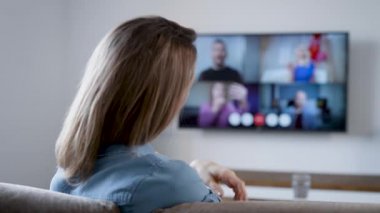 Bir kadın video bağlantısıyla evde konuşuyor. Arkadaşlarla TV 'de görüntülü sohbet.
