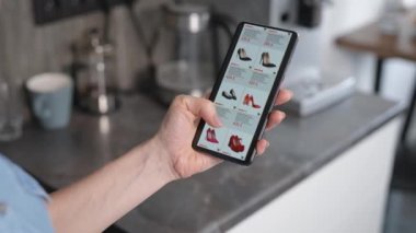 Bir kadın online alışveriş yapıyor. Bir ev kadını çevrimiçi bir mağazadan yeni ayakkabılar seçiyor..
