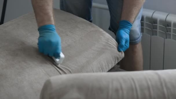 Manžel čistí pohovku a polštáře speciálním štětcem — Stock video