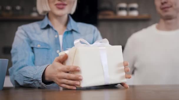Mutfakta genç ve güzel bir çift var. Adam karısı için bir sürpriz hazırladı. Güzelce paketlenmiş bir hediye sunulur. — Stok video