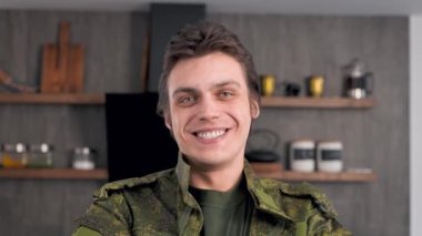 Asker kıyafetli genç bir askerin portresi. Adam evine döndüğü için mutlu..