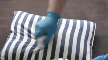 Koca kanepeyi ve yastıkları özel bir fırçayla temizliyor.