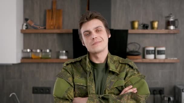 Seorang prajurit laki-laki di rumah sendirian. Pemuda berseragam militer.. — Stok Video