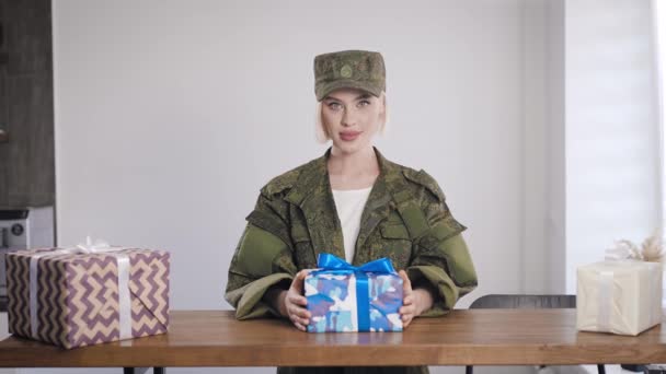 Une fille en vêtements kaki aime les cadeaux. Uniforme militaire sur une blonde — Video
