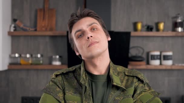 Een mannelijke soldaat alleen thuis. Jongeman in militair uniform. — Stockvideo