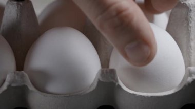 Çiftçi yumurtayı kutudan alır. Tavuk yumurtaları tüm ülkelerde çok popüler bir üründür..