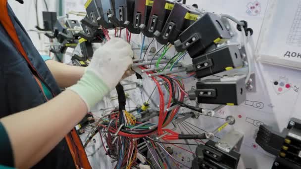 Výroba automobilové elektroniky v podniku. Zaměstnanec sbírá dráty ve svazcích. — Stock video