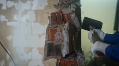 Elinde balyoz olan bir işçi tuğla duvarı yıkar. Hayattaki ve işteki engelleri aşma kavramı.