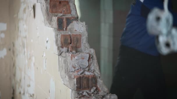 Het ontmantelen van een onnodige bakstenen muur tijdens bouwwerkzaamheden in een oud gebouw. — Stockvideo