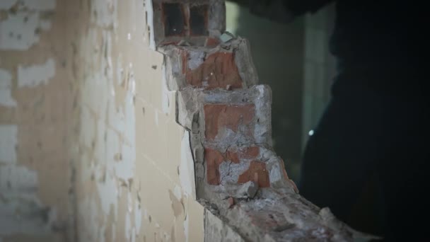 Trabalho masculino duro num estaleiro. Trabalhadores demolir uma parede de tijolo desnecessário. — Vídeo de Stock