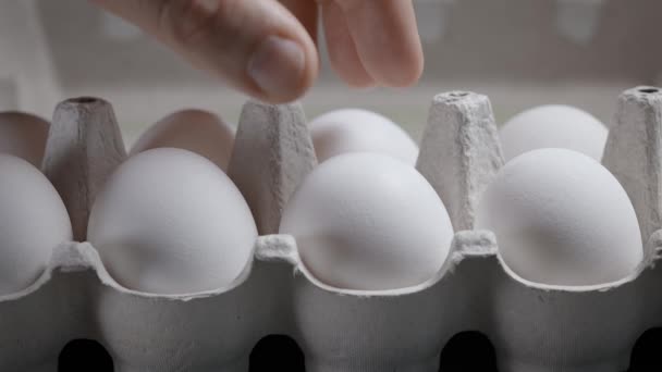 Ovo de galinha ao pequeno-almoço. Uma mão de homem tira um ovo da caixa. — Vídeo de Stock