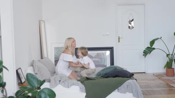 Lykkelig mor og søn frolic om morgenen. Lys lejlighed med stilfuldt design. – Stock-video
