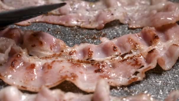 O cozinheiro frita o bacon suculento em uma panela. Um pedaço muito saboroso e nutritivo de carne em um braseiro. — Vídeo de Stock