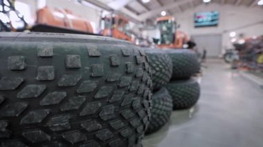 Ön planda tüm arazi araçlarından ya da kamyonlardan gelen dev tekerlekler var. Girişimin otomotiv montaj dükkanı.