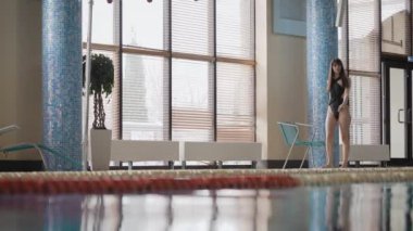 Mayolu güzel bir kadın havuzda yürüyor..