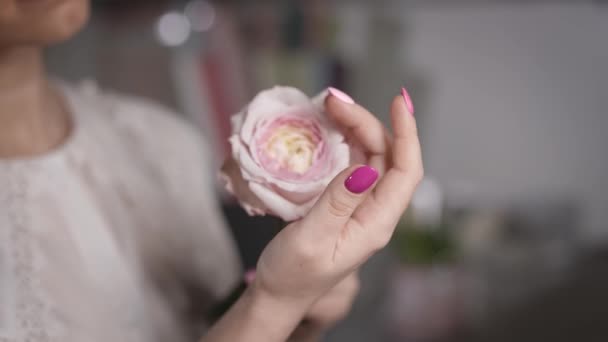 De la tendresse à chaque contact. La femme admire la beauté de la rose. — Video