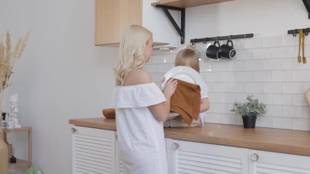 Mutter und Sohn in einer hellen Küche. Gemeinsam macht Hausarbeit mehr Spaß. — Stockvideo