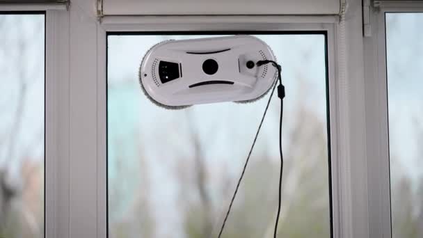 The automatic robot assistant washes the glass of the window. A modern vacuum apparatus helps in cleaning. — Stock Video