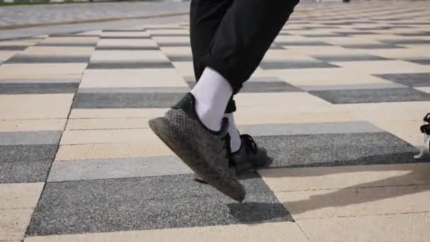 Mens feet in sneakers on an electric scooter. Youth electric city transport. — Stock Video