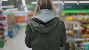 Bir kadın markette yürüyor. Süpermarketten yiyecek almak..