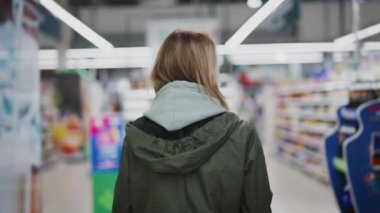 Bir kadın markette yürüyor. Süpermarketten yiyecek almak..