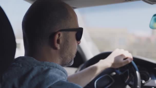 Ταξιτζής με μούσι στη δουλειά. Ένας άντρας οδηγεί αυτοκίνητο.. — Αρχείο Βίντεο