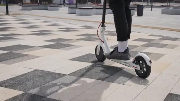 Mens feet in sneakers on an electric scooter. Youth electric city transport. — Stock Video