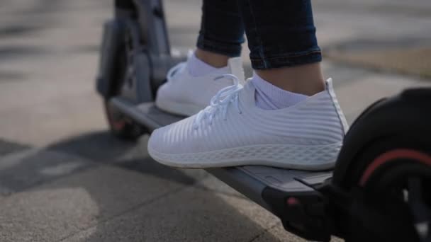 電動スクーターの女性の足。女性が街中のスクーターに乗ってる. — ストック動画