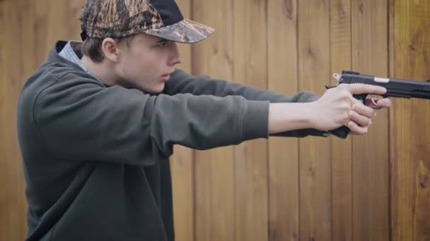 Bűnöző tinédzser pisztollyal. A fickó agresszív és harcra kész.. — Stock videók