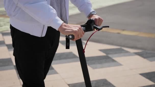 Close-up van de handen op het stuur. De man bestuurt een elektrische scooter. — Stockvideo