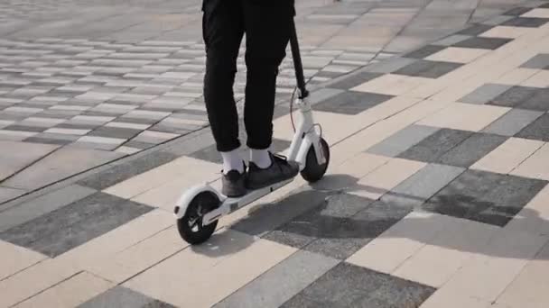 踩着电动车穿运动鞋的男人。青年电气化城市交通. — 图库视频影像