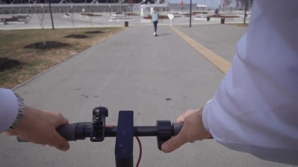 Vue à la première personne. Un homme suit une femme sur son scooter électrique. — Video