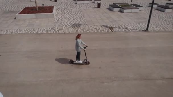 Aerial view of people traveling. A man and a woman are riding electric scooters. — Stock Video