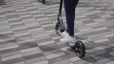 Elektrikli scooter 'da kadın bacakları. Bir kadın şehirde scooter kullanıyor..