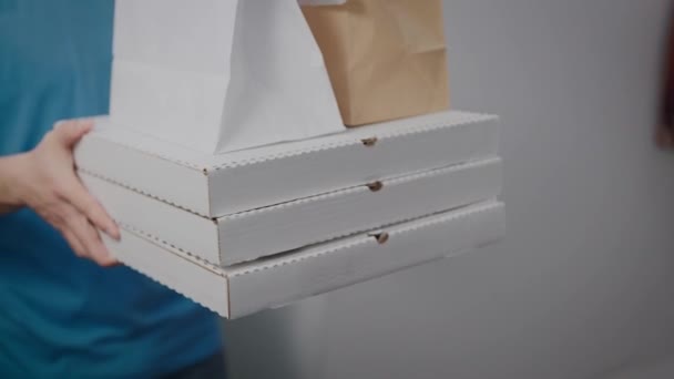 Dodavatel jídla předá objednávku ženě. Detailní záběr krabic od pizzy a balíčků potravin. — Stock video