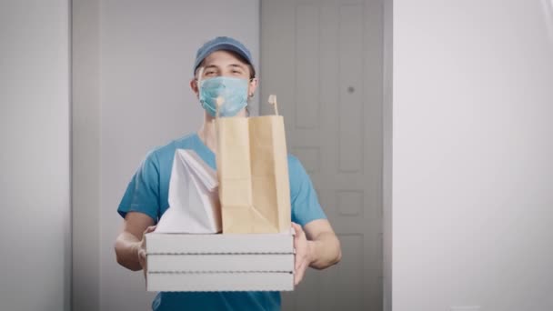 Tukang pos memegang perintah dengan makanan di tangannya. Potret seorang remaja pada pekerjaan paruh waktu. — Stok Video