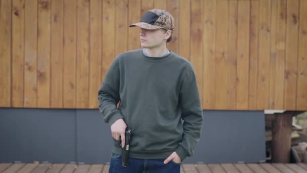 Fiatal, kiskorú férfi pisztollyal. A díler az utcán védi a területét.. — Stock videók