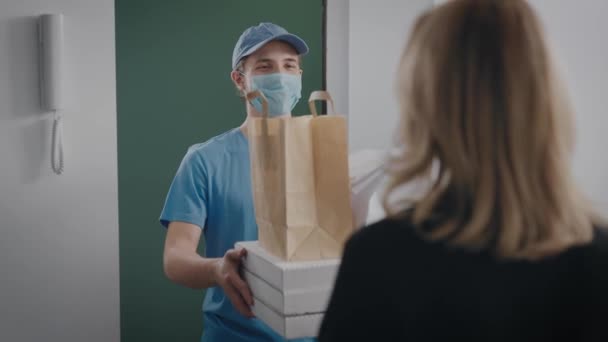 Een jonge koerier bracht eten naar het huis. Een zakenvrouw bestelde in een restaurant.. — Stockvideo