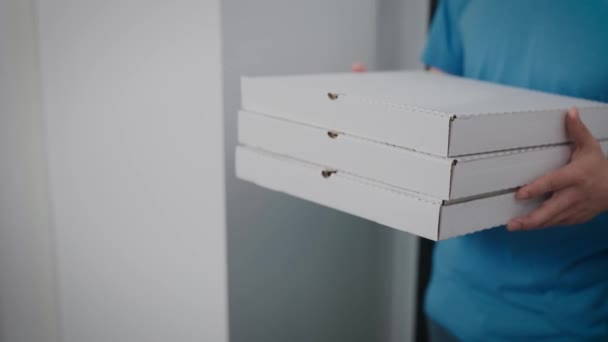 Un livreur de nourriture remet l'ordre à une femme. Gros plan sur les boîtes à pizza et les emballages alimentaires. — Video
