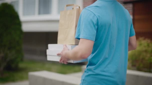 Un uomo irriconoscibile consegna cibo trasporta scatole di pizza e sacchetti di cibo. — Video Stock