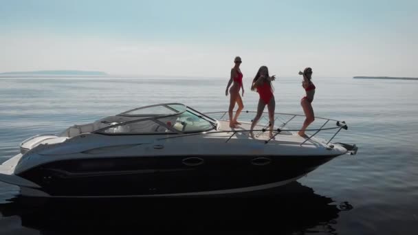 Вид с воздуха, танцующие три красивые женщины, у них была вечеринка на моторной яхте.. — стоковое видео