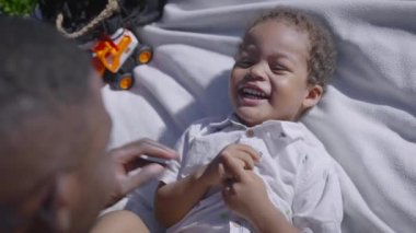 Parktaki afro adam ve çocuk iyi vakit geçiriyorlar. Baba ve oğul eğleniyor..