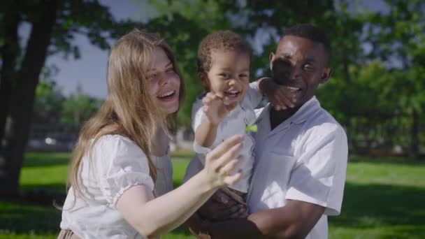 Unge multiraciale familie i parken. Mor far og lille dreng er lykkelige sammen. – Stock-video